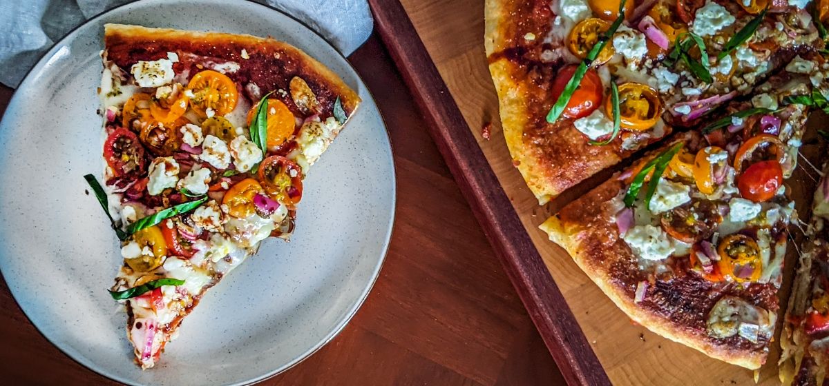 Grilluð pizza með fetaosti. kokteil tómötum og basil